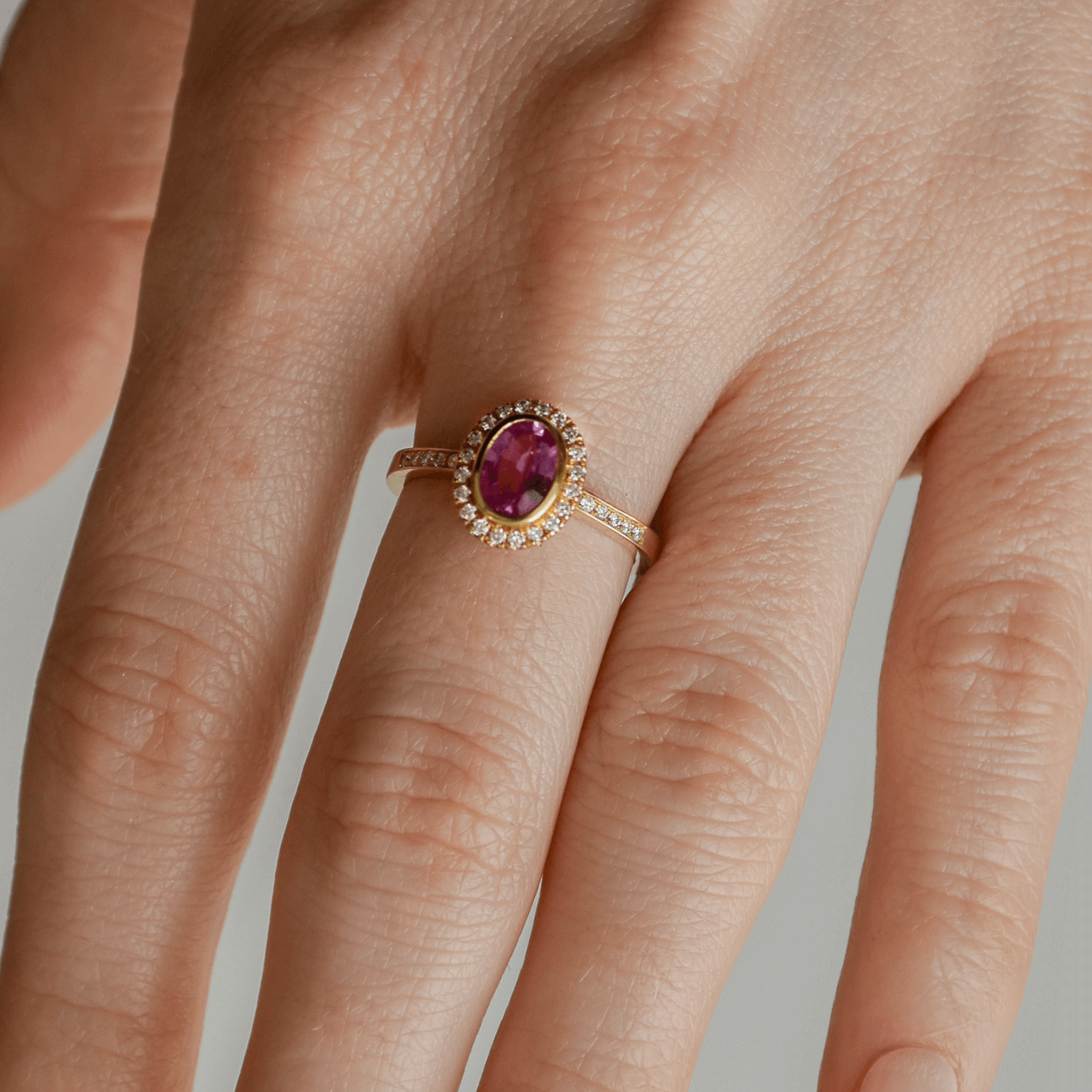 BLOOM złoty pierścionek z owalnym różowym szafirem i diamentami halo