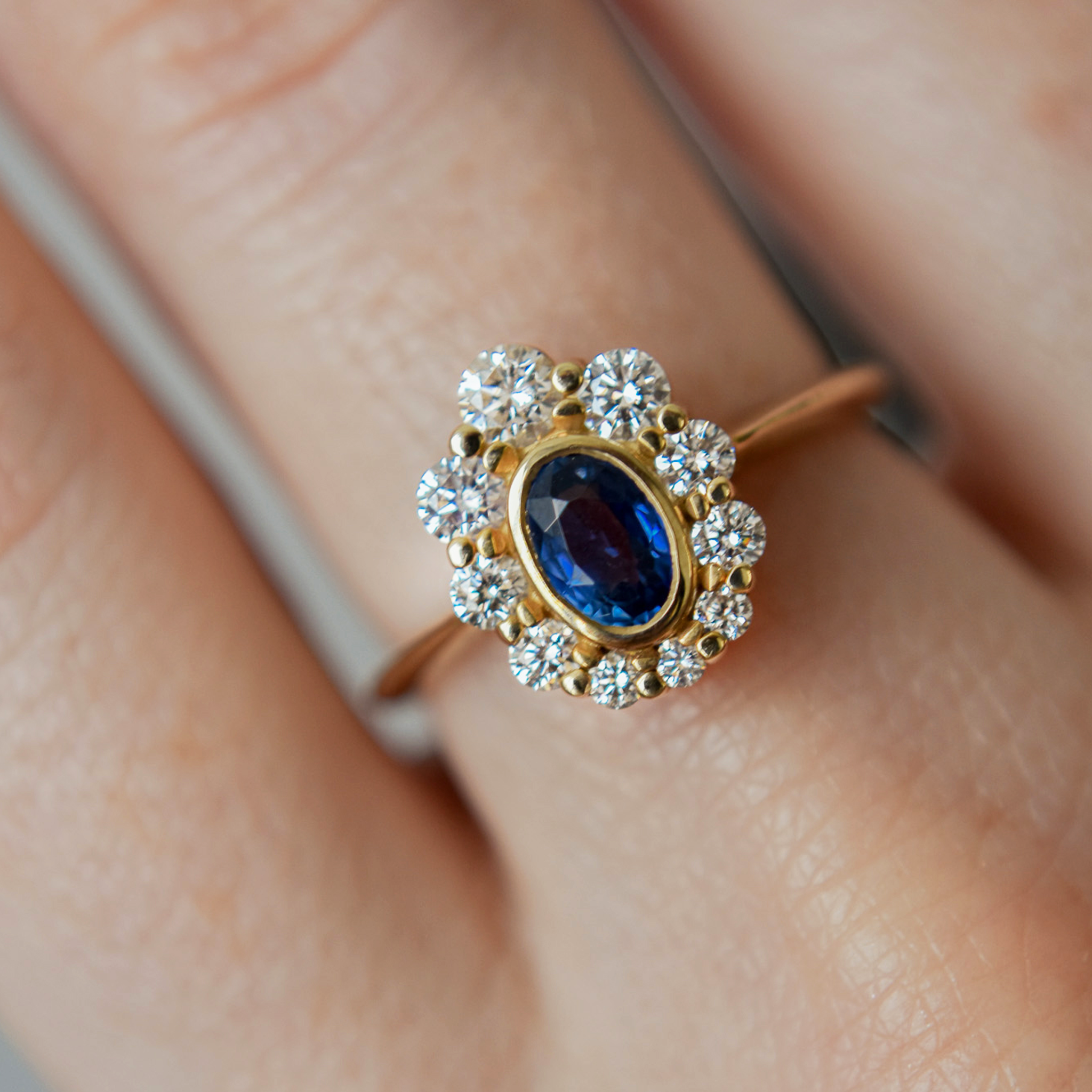 PEACOCK złoty pierścionek z owalnym granatowym szafirem i brylantami halo